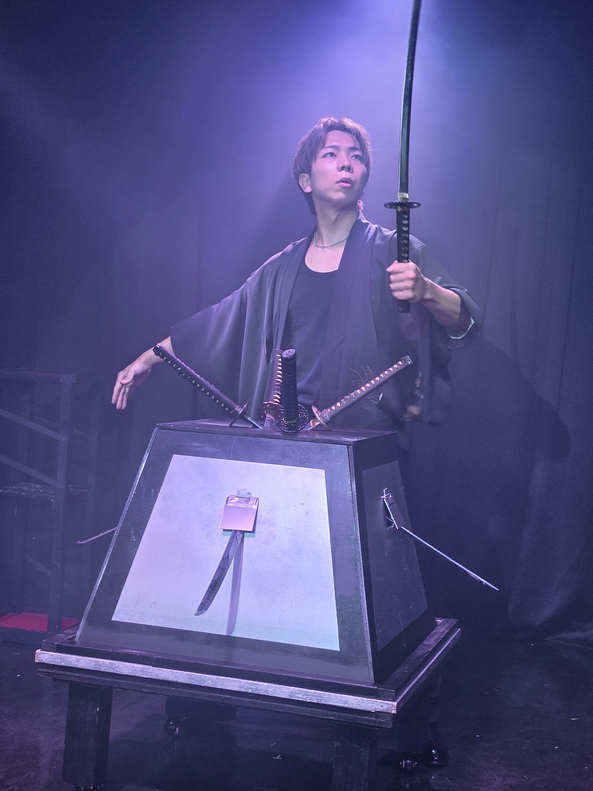 kurosaki hiroto stage katana illusion 01 黒羽織姿のマジシャン黒崎博斗が日本刀を掲げる和風の剣刺しイリュージョン