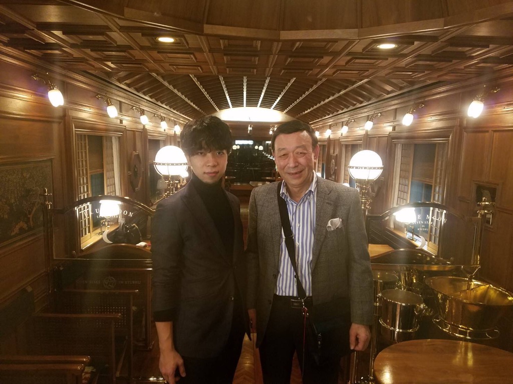 ななつ星 in 九州のラウンジカーで、ゲストの男性と並ぶ黒崎博斗